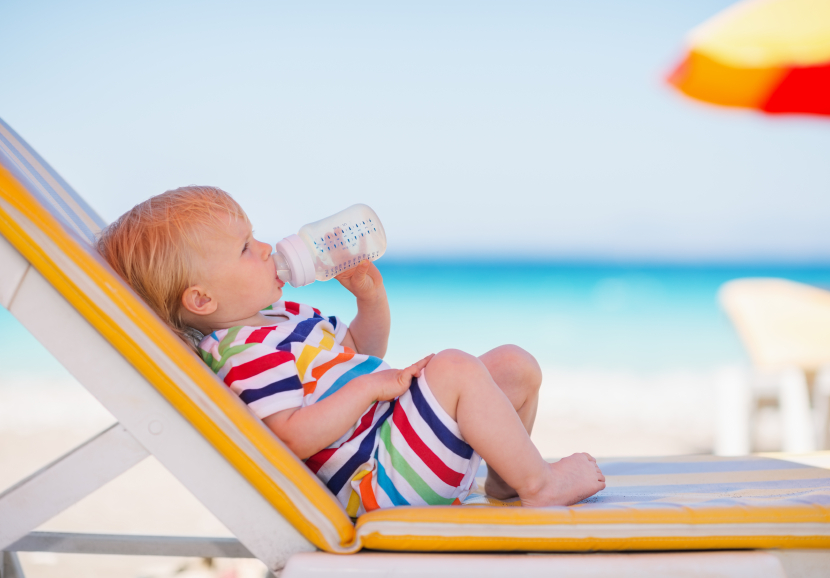 Portrait of baby on sunbed drinking water