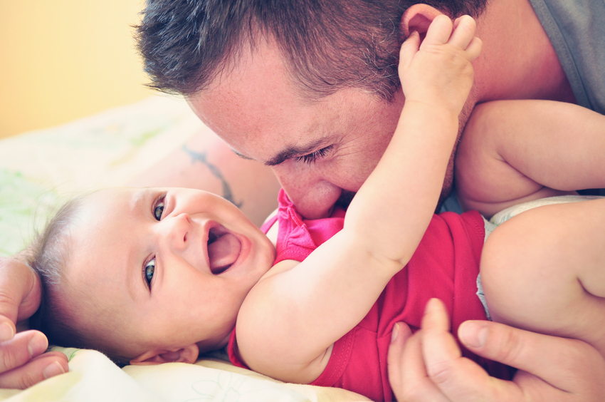 Father playing with his little happy and smiling baby daughter