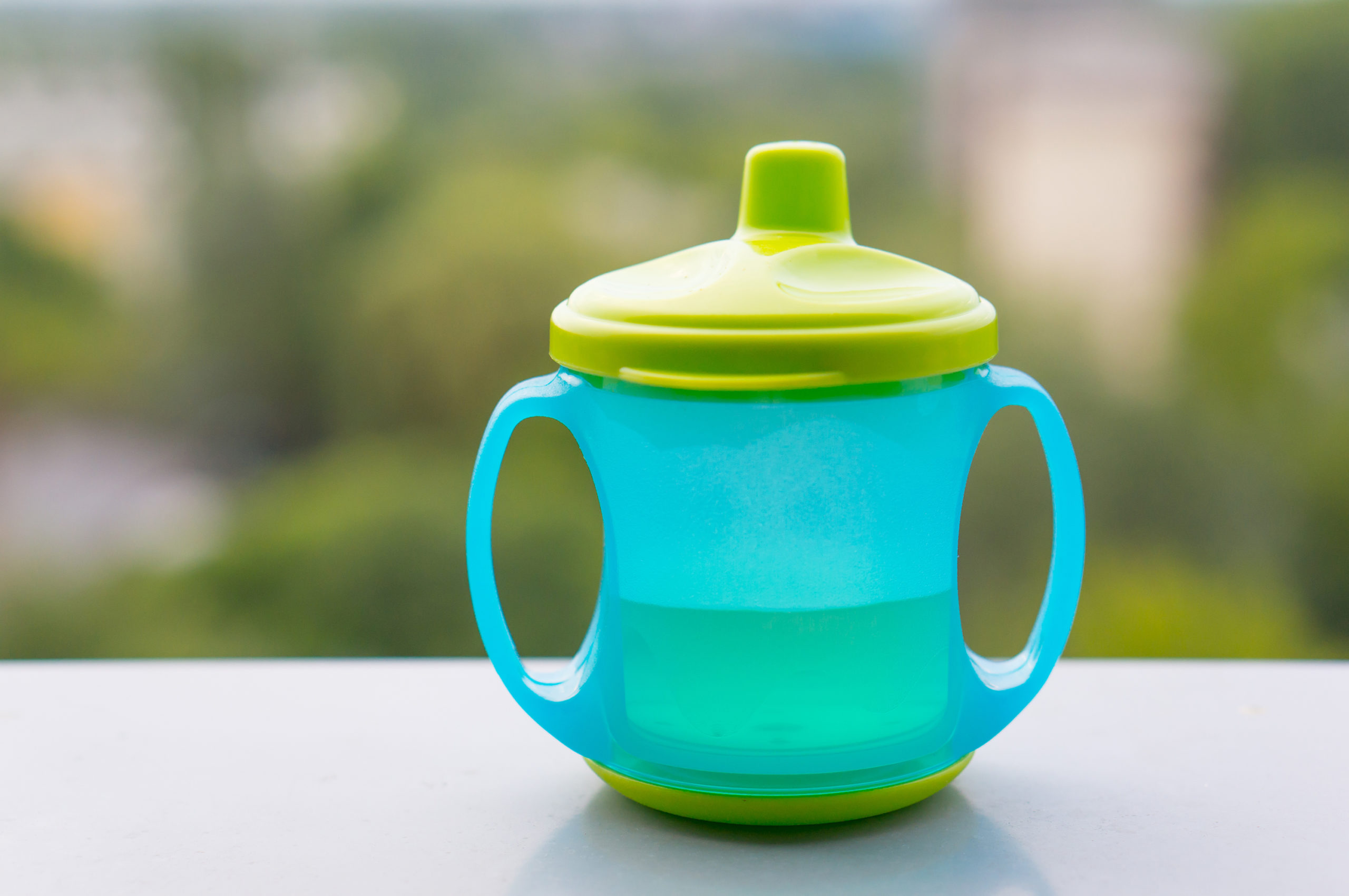 Green plastic baby drinking cup