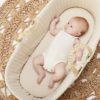 baby in linen moses basket