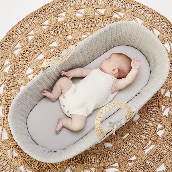 baby in dove coloured moses basket