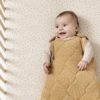 baby smiling with brown spotted dress