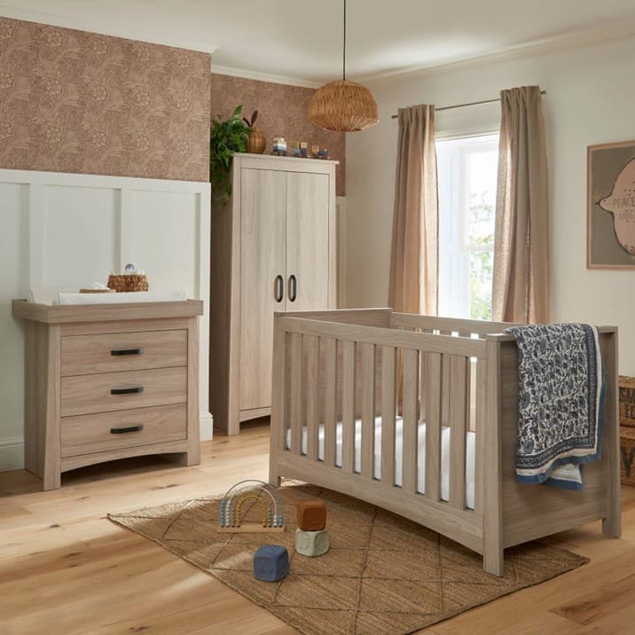 A baby room with a cot and dresser